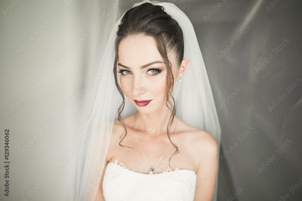 Beautiful young bride with makeup and hairstyle in bedroom, newlywed woman final preparation for wedding. Happy girl waiting groom. Portrait soft focus Beautiful young bride with makeup and hairstyle in bedroom, newlywed woman final preparation for wedding. Happy girl waiting groom. Portrait soft focus