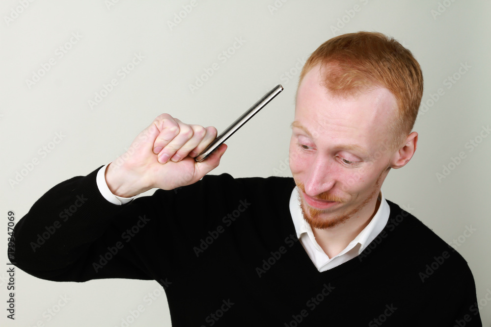 Angry businessman aggressive talking on the phone. Ginger on a white background. Angry businessman aggressive talking on the phone. Ginger on a white background.