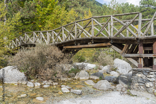 Old wooden footbridge with rails over river. Mount Olympus, Pieria, Greece.