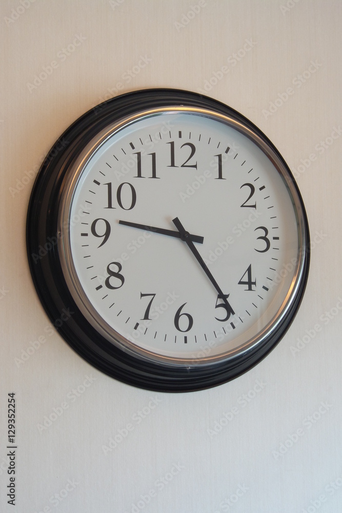 Classic clock hanging on the white wall Classic clock hanging on the white wall
