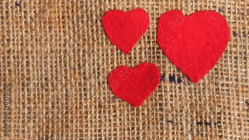 Three red heart shapes on jute