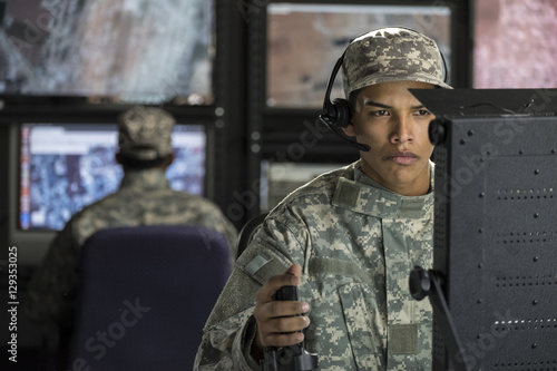 Military drone operator looking at computer screen