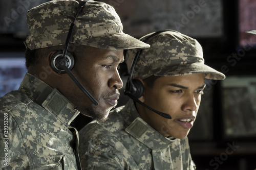 2 military drone operators in front of a computer, close up