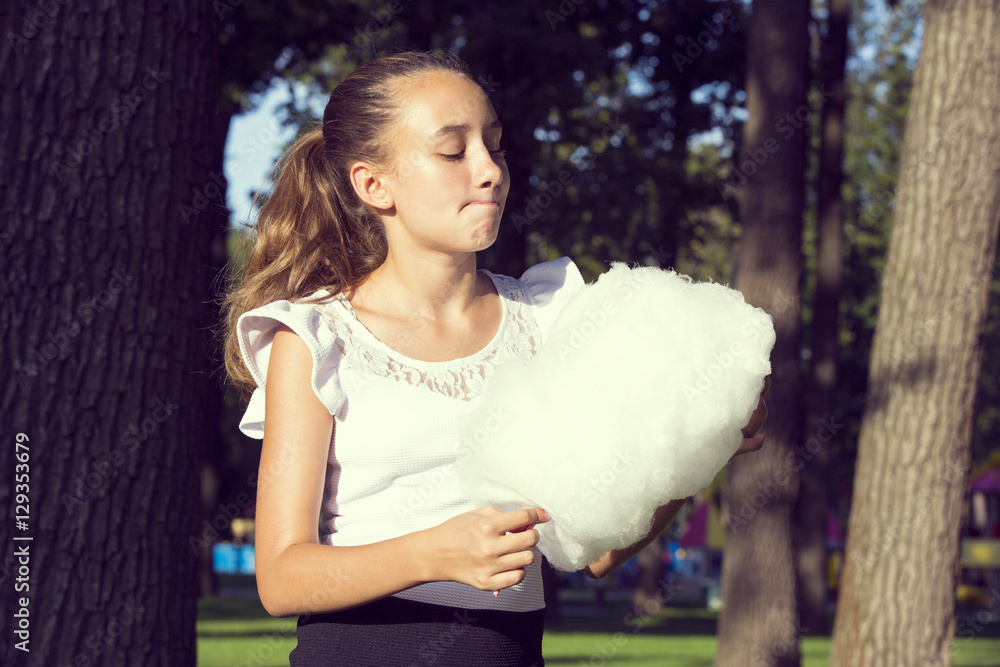 Girl eating cotton candy in a summer park Girl eating cotton candy in a summer park