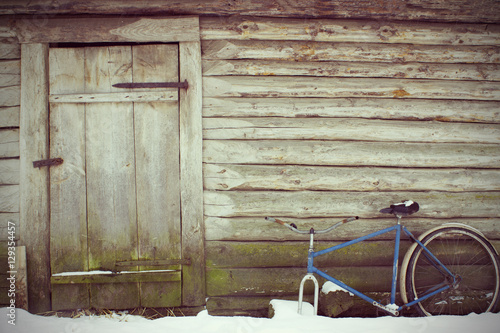 Abandoned rustic look with an old door and a broken bicycle. Vintage toming.
