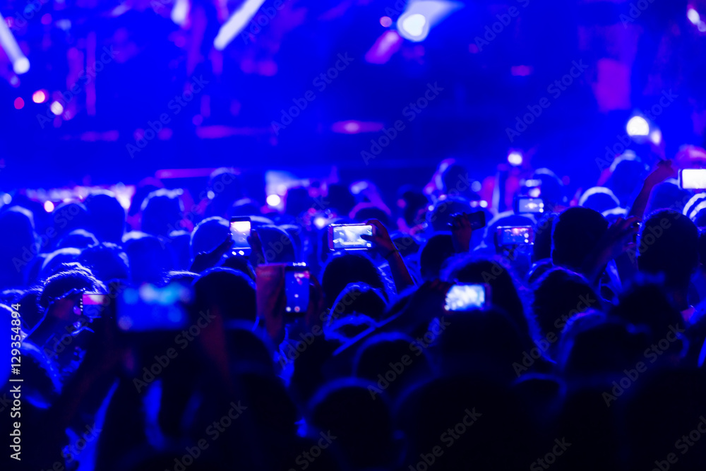 Obraz premium Hand with a smartphone records live music festiva