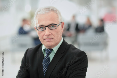 Portrait of mature businessman with colleagues interacting on b