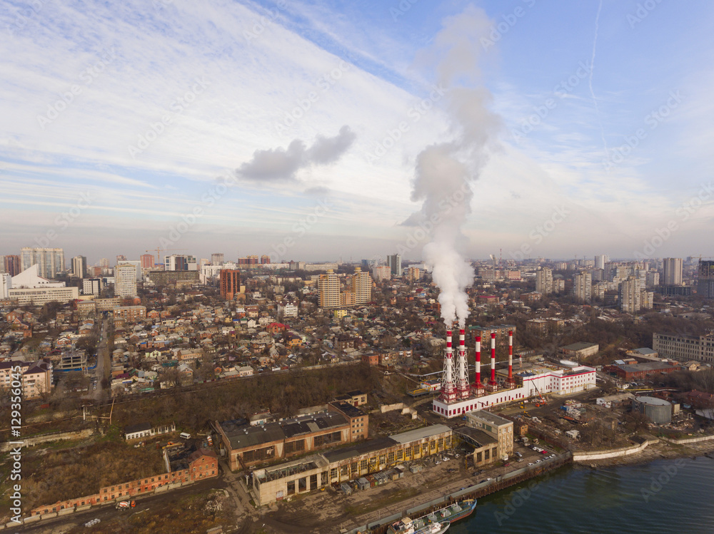 Modern aerial cityscape with a thermal power plant and river. Aerial view.