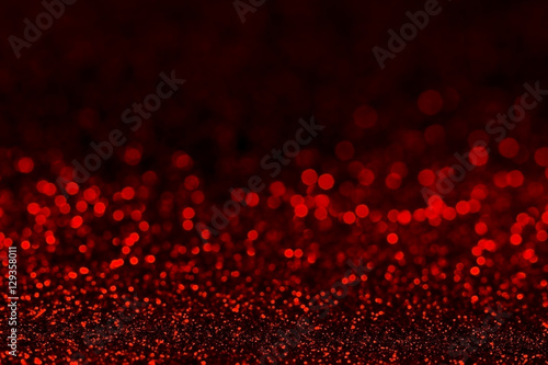 Abstract dark red glitter background with shining light and soft bokeh, festive colors