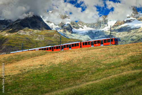 Electric tourist train with high mountains,Switzerland,Europe