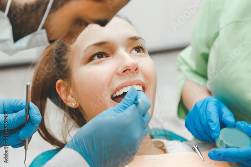 The dentist checks the condition of the teeth  a beautiful girl.