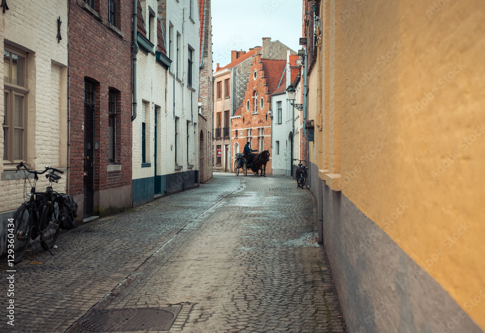 Horseman on the narrow street in Bruges, Belgium