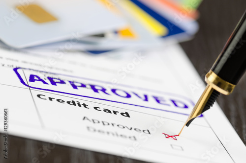 Credit card application approved, close up shot of a form, cards and pen.