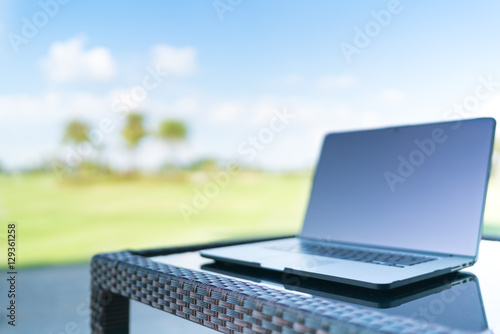 Fotografie Laptop on golf course blur background with copy space, business or work from any