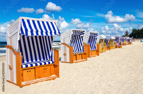 Blue and white wicker chairs on sandy beach