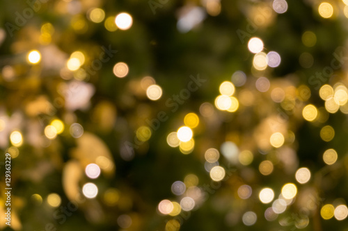 christmas tree bokeh light in green yellow golden color, holiday abstract background, blur defocused
