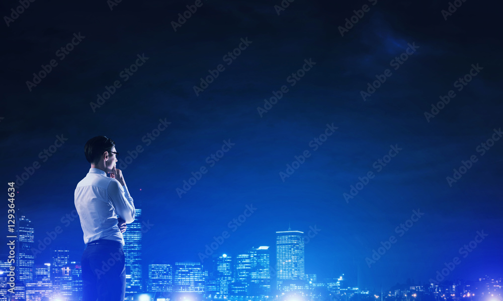 Businessman viewing night glowing city Businessman viewing night glowing city