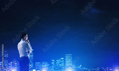 Businessman viewing night glowing city