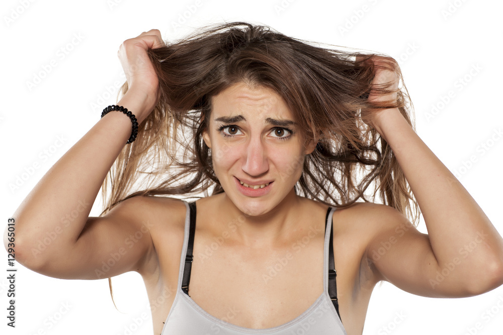 portrait of nervous young woman who pulls her hair portrait of nervous young woman who pulls her hair