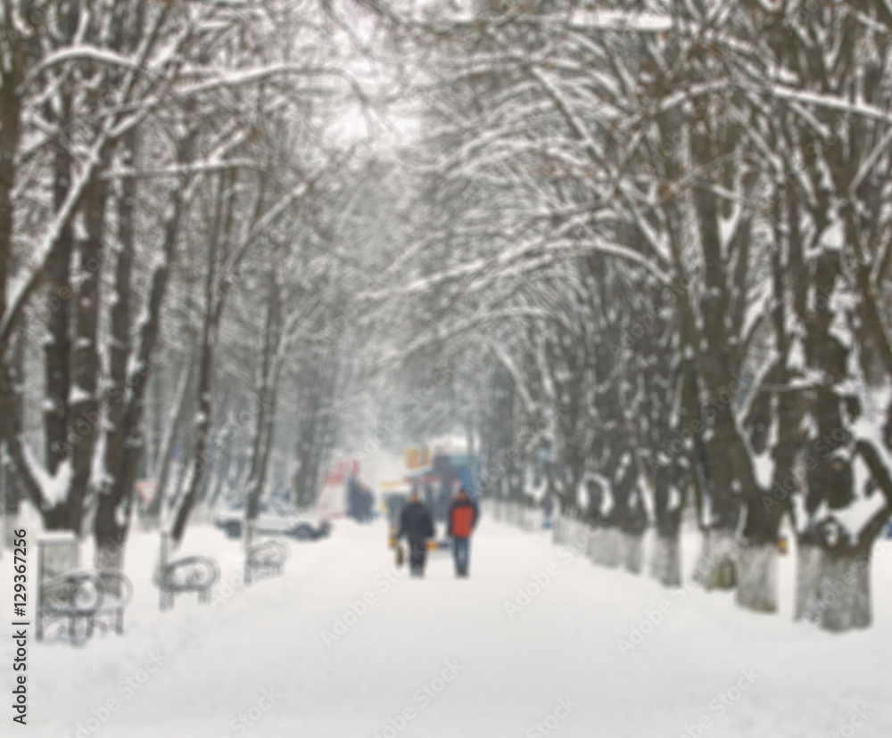 People walk on a snowy street. Blur picture