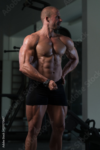 Fitness Shaped Muscle Man Posing In Dark Gym