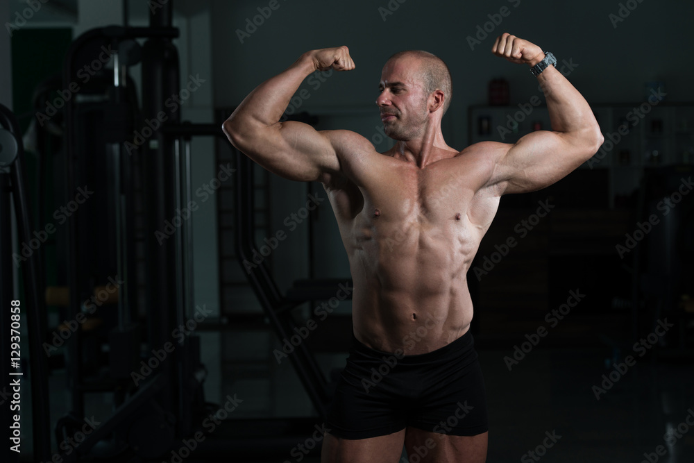 Bodybuilder Performing Front Double Biceps Pose In Gym
