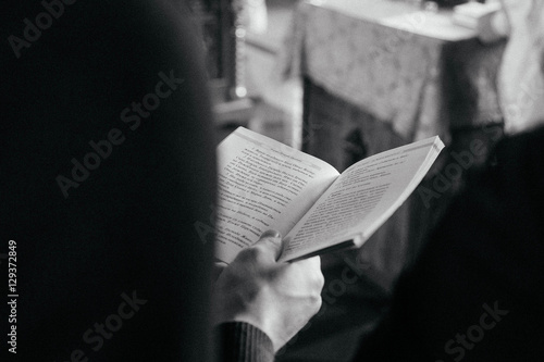 book in man's hand in russian church