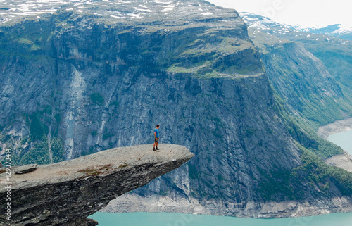 Man standing iconic cliff at Trolltunga Norway