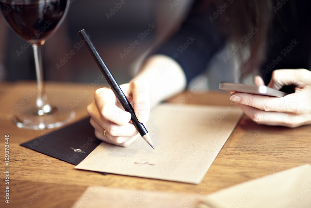 Having lunch with red wine in a cafe or restaurant. Hipster lifestyle. Blank paper envelope, phone. wooden table Having lunch with red wine in a cafe or restaurant. Hipster lifestyle. Blank paper envelope, phone. wooden table