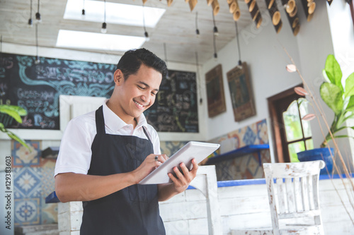 young male cafe owner with tablet
