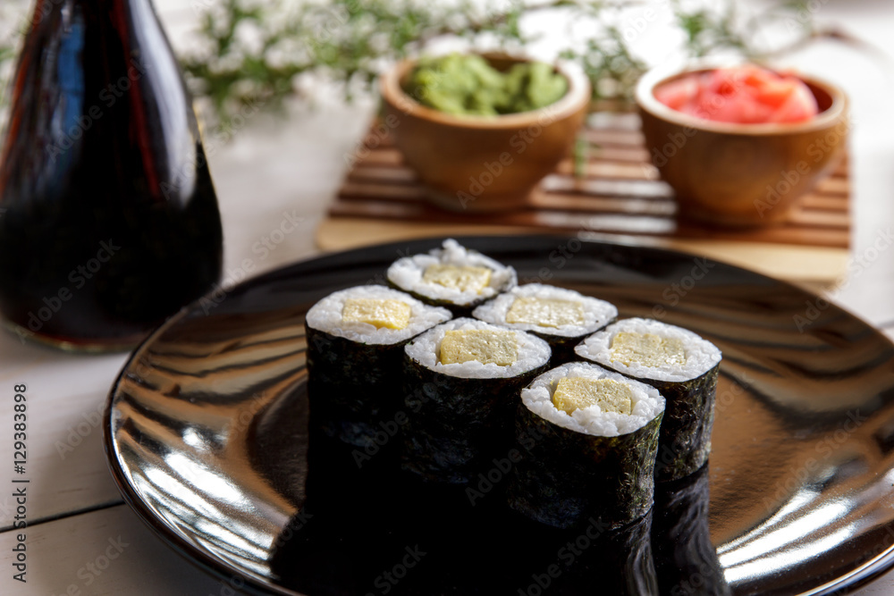 japanese food tamago maki sushi on black plate