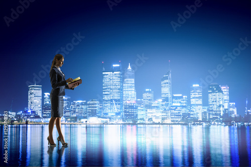 Fototapeta Naklejka Na Ścianę i Meble -  Rear view of businesswoman looking at night city . Mixed media