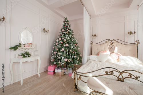 Calm image of interior Classic New Year Tree decorated in a room with bed