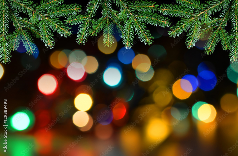 Fir tree branch with colorful lights bokeh. Christmas background.