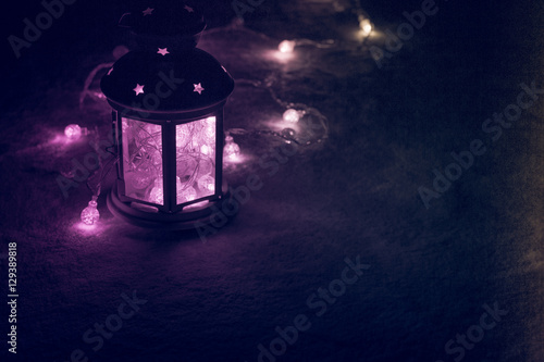 Holiday Greeting Card or Background. Christmas Lights and Candle Lantern on Dark Background. Christmas at Home. New Year Holiday Template.