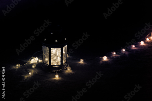 Holiday Greeting Card or Background. Christmas Lights and Candle Lantern on Dark Background. Christmas at Home. New Year Holiday Template.