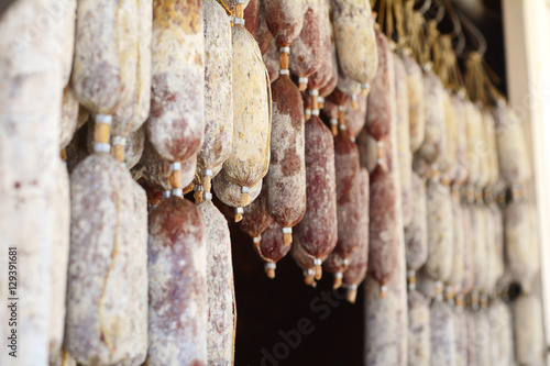 Hanging salami sausages in street market.