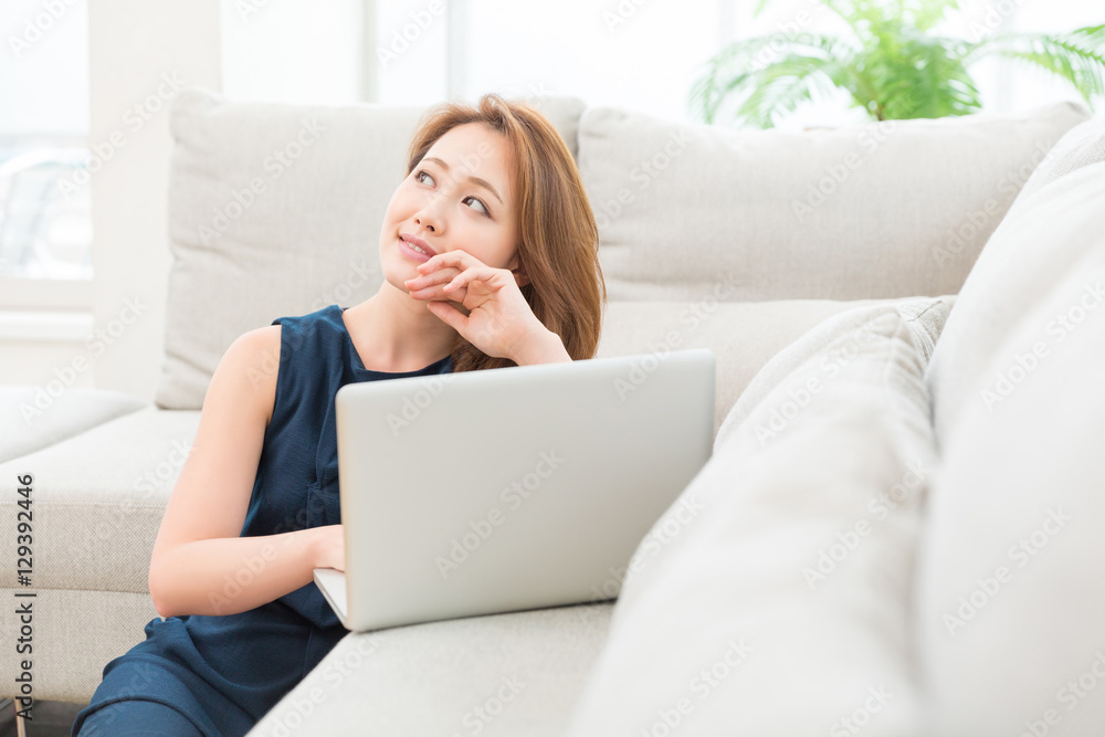 部屋でパソコンを見る女性