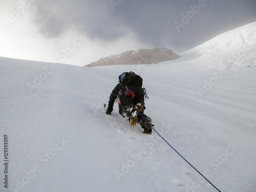 a mountain climber on a steep north face in the Swiss Alps photo