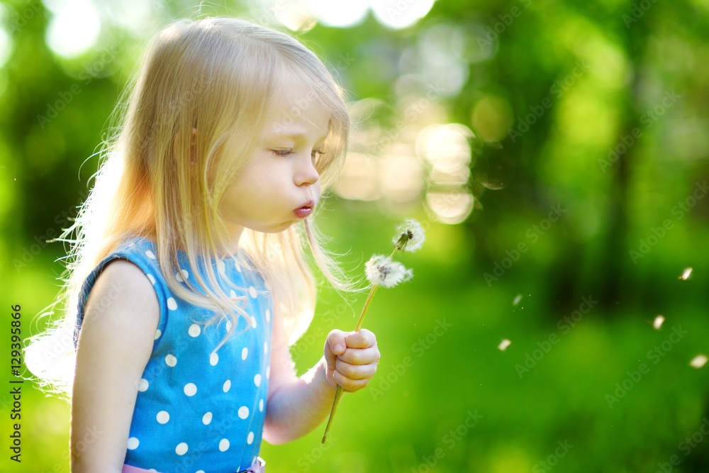 Pretty little blonde girl blowing off a dandelion Pretty little blonde girl blowing off a dandelion
