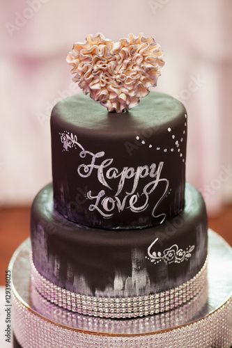 Decorated chocolate wedding cake with brown ribbon, closeup
