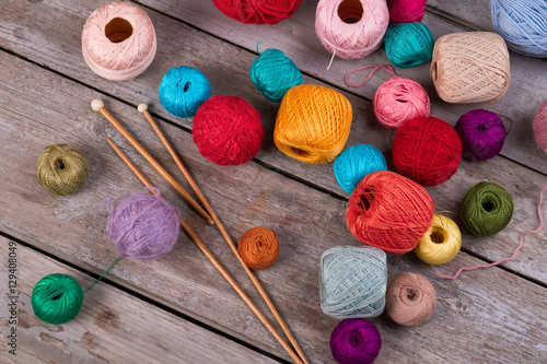 Many colorful yarn with wooden knitting needles.
