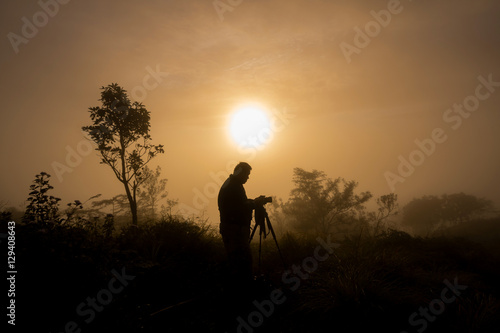 photographer takes photos the first rays of the rising sun on Mountain. Dreamy fogy landscape  spring orange pink misty sunrise  