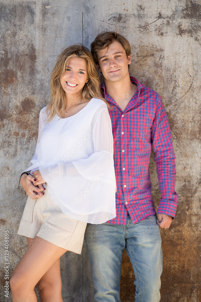 Portrait of smiling young and beautiful couple in the street