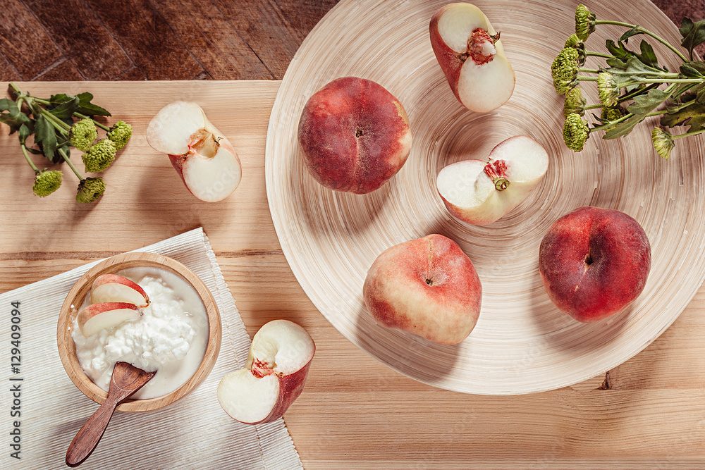 Breakfast with ripe peaches and cottage cheese on  wood board background. Top view. Rustic style.