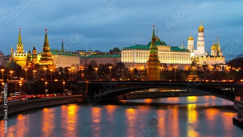 Moscow, Russia day to night time-lapse. River with aerial view of illuminated popular landmark in Moscow - Kremlin in Russia. Colorful cloudy sky. Touristic boats and car traffic