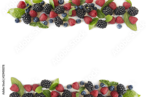 Various fresh summer berries on white background. Ripe blueberries, raspberries and blackberries. Berries at border of image with copy space for text. 