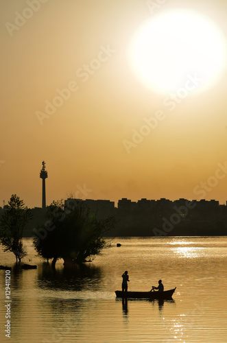 Photography silhouette of fishermen with and orange sun