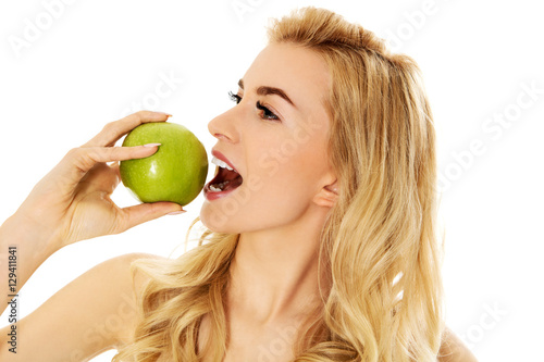 Young happy woman eating fresh green apple