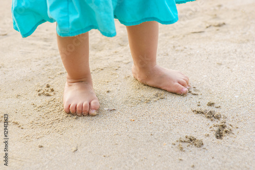 Toddler baby doing his first steps on the sand near the bank © DN6